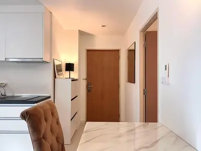 a kitchen with a table and a chair in a room at Best City Location with 3-min Walk to Everything in Bangkok