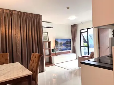 a kitchen and living room with a table and chairs at Best City Location with 3-min Walk to Everything in Bangkok