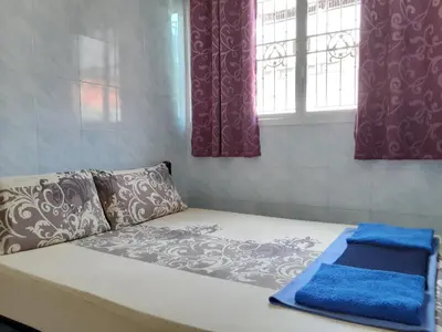 a bed in a room with curtains and a window at New Central Guesthouse in Bangkok