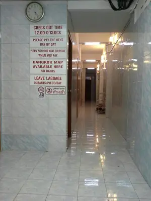 a hallway with a sign on the wall in a building at New Central Guesthouse in Bangkok