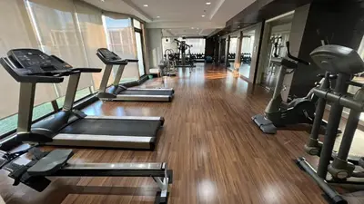 a gym with several treadmills and elliptical machines at Spacious 2 King Beds, Balcony with View, Near Nana BTS in Bangkok