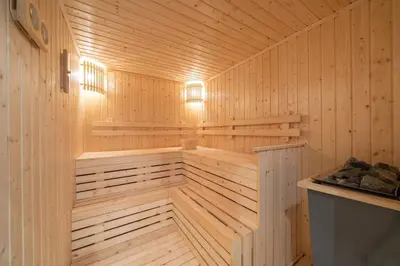 a sauna with wooden walls and ceilings and lights at Amazing Pool and Luxury Condo Unit Near Phrom Phong BTS in Bangkok