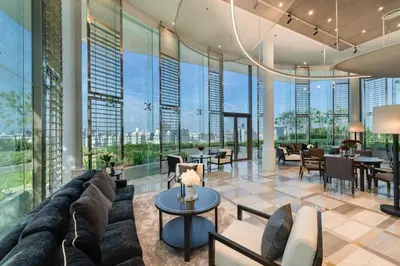 a living room with a couch and tables and windows at Amazing Pool and Luxury Condo Unit Near Phrom Phong BTS in Bangkok