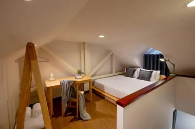 a small attic bedroom with a bed and a desk at Kraft Haus in Khlong San