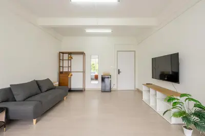 a living room with a couch and a flat screen tv at Glow House Sukhumvit 54 in Bangkok