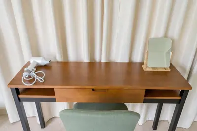 a wooden desk with a phone sitting on top of it at Glow House Sukhumvit 54 in Bangkok