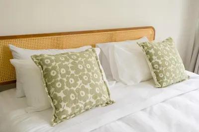 a bed with white pillows and a bunch of pillows at Glow House Sukhumvit 54 in Bangkok
