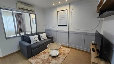 a living room with a couch and a table at Easy Living in Bang Khen