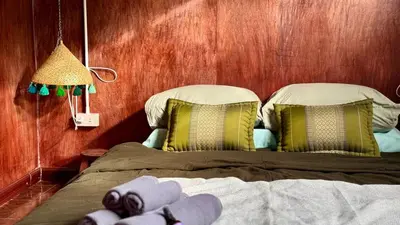 a bedroom with a bed with a stuffed animal on it at Baan PadSeeEw - Rooftop Riverview 2nd floor in Thonhuri