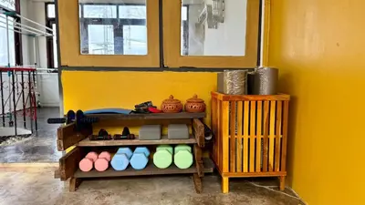 a room with a shelf with shoes and a yellow wall at Baan PadSeeEw - Rooftop Riverview 2nd floor in Thonhuri