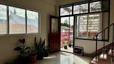 a room with windows and a door with potted plants at Baan PadSeeEw - Rooftop Riverview 3rd floor in Thonhuri