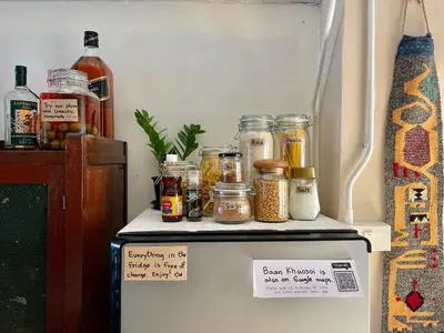 a refrigerator with jars of food on top of it at Baan KhaoSoi - Rooftop House in Talad Noi in Samphanthawong