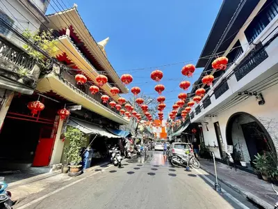 a street with red lanterns hanging over a street at Baan KhaoSoi - Rooftop House in Talad Noi in Samphanthawong