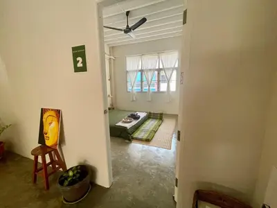 a living room with a couch and a ceiling fan at Baan KhaoSoi - Rooftop House in Talad Noi in Samphanthawong
