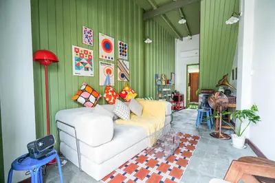 a living room with a white couch and green walls at Baan Lek Tee 6 - 9Chinatown near Yaowarat and MRT in Bangkok