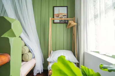 a green room with a bed and a window at Baan Lek Tee 6 - 9Chinatown near Yaowarat and MRT in Bangkok