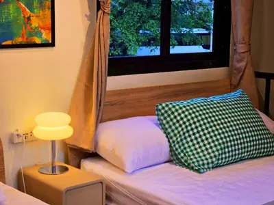 a room with a bed with a window and a pillow at Cozy Canal House 1 min to MRT & Street Foods in Bangkok