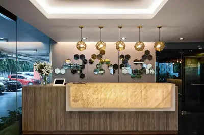 a lobby of a restaurant with a counter and pendant lights at Diamond Residence Ratchada in Bangkok