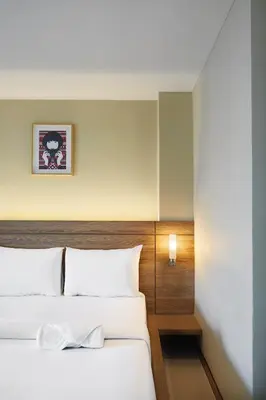 a bedroom with two beds and a wall at Diamond Residence Ratchada in Bangkok