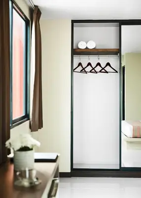 a room with a window and a table with a mirror at Diamond Residence Ratchada in Bangkok
