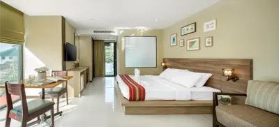 a bedroom with a bed and a desk and a chair at Diamond Residence Ratchada in Bangkok
