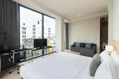 a bedroom with a white bed and a large window at The Residence on Thonglor by UHG in Bangkok