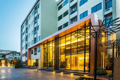 a large building with large windows on a city street at Aim House Bangkok No Parking in Bangkok