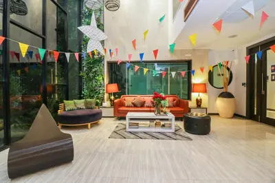 a living room with a couch and a table and flags at Aim House Bangkok No Parking in Bangkok