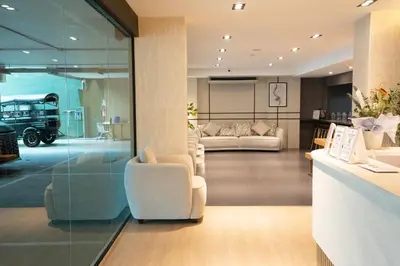 a living room with two white chairs and a couch at Infinite Hotel-Ratchada in Bangkok