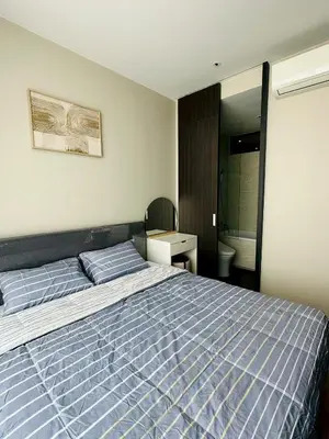 a bedroom with a blue bed and a bathroom at The Fine 2-bedroom in Bangkok