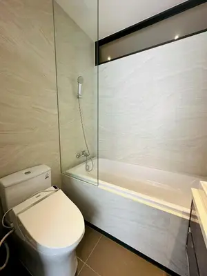 a bathroom with a toilet and a shower and a tub at The Fine 2-bedroom in Bangkok
