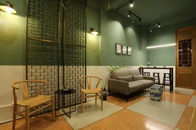 a living room with a couch and two chairs at Kudi Hostel in Bangkok