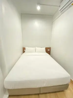 a bedroom with a white bed in a white room at Kudi Hostel in Bangkok