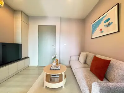 a living room with a couch and a table at Functional and comfortable-FastWiFi-MRT HuaiKhwang in Bangkok