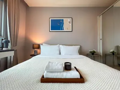 a bedroom with a large bed with a tray on it at Functional and comfortable-FastWiFi-MRT HuaiKhwang in Bangkok