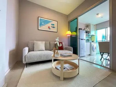 a living room with a couch and a table at Functional and comfortable-FastWiFi-MRT HuaiKhwang in Bangkok