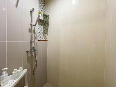a bathroom with a shower with a shower head at Functional and comfortable-FastWiFi-MRT HuaiKhwang in Bangkok