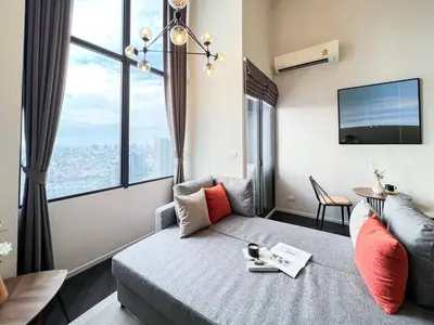a living room with a couch and a large window at Elegant 1BR Condo - Ultra Fast WiFi - BTS On-Nut in Bangkok