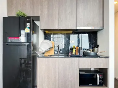 a kitchen with a sink and a microwave at Elegant 1BR Condo - Ultra Fast WiFi - BTS On-Nut in Bangkok