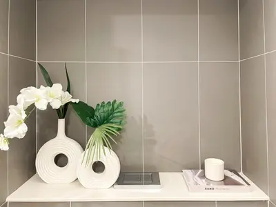 a white vase with flowers on a shelf in a bathroom at Elegant 1BR Condo - Ultra Fast WiFi - BTS On-Nut in Bangkok
