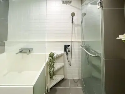 a white bathroom with a shower and a sink at Elegant 1BR Condo - Ultra Fast WiFi - BTS On-Nut in Bangkok
