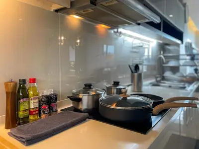 a kitchen with two pots and pans on a counter at Spacious City 118 SQM Fast WiFi BTS Chong Nonsi in Bangkok