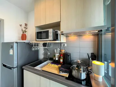 a kitchen with a sink and a microwave and a refrigerator at Cozy Park-view 1BR - Ultra Fast Wifi - BTS Bangna in Bangkok