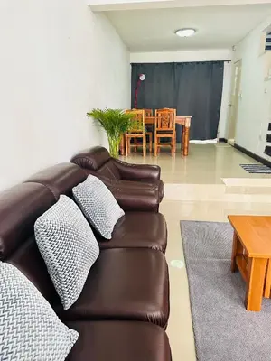 a living room with a leather couch and a table at Bangkok Halwa home in Sathani Ban Hua Mak