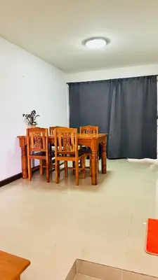 a dining room with wooden tables and chairs in front of a screen at Bangkok Halwa home in Sathani Ban Hua Mak