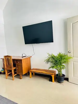 a room with a desk and a tv on a wall at Bangkok Halwa home in Sathani Ban Hua Mak