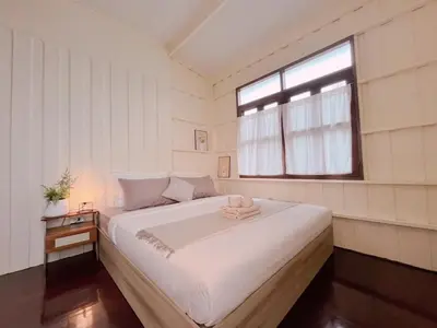 a bedroom with a large white bed with a window at Entire House 3BR - White and Green Guesthouse in Bangkok Yai