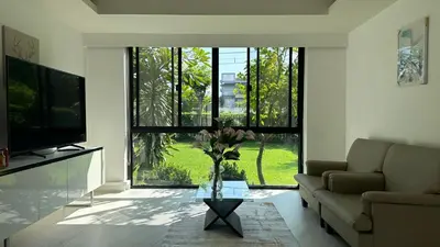 a living room with a couch and a large window at Bangkok Manor Two\u66fc\u8c37\u8d30\u53f7\u5e84\u56ed in Bangkok