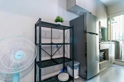 a kitchen with a fan next to a refrigerator at TC Contel at Bts Samrong in Ban Khlong Samrong