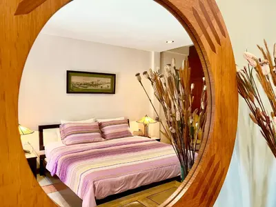 a bedroom with a bed and a round mirror at WiNNiNE Cozy Home in Bangkok